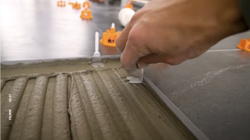 Helix-clips onder de tegelranden plaatsen tijdens het tegelen.