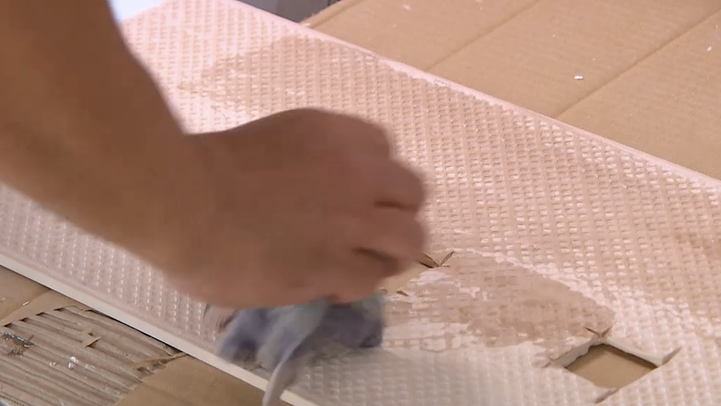 Verwijder onvlakke stukken van de tegel met behulp van een vijl, schuurpapier of een tegelkniptang. Maak de gesneden rand van de tegel schoon met een vochtige spons om resten te verwijderen. 